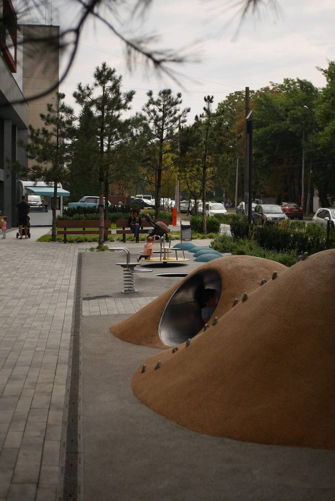 INFINITY PARK: дитячий майданчик і сосни, що відділяють двір від дороги